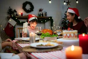 carino poco ragazza nel Santa cappello apertura Natale presente e sorridente. foto