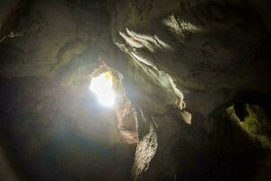 il sole brilla attraverso il grotta nel il buio foto