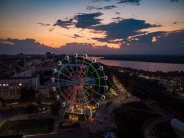 bellissimo tramonto al di sopra di il città con un' illuminato Ferris ruota. foto