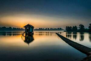 un' piccolo Casa si siede su il riva di un' lago a tramonto. ai-generato foto