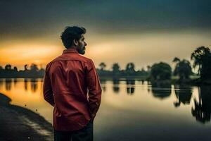 un' uomo nel rosso camicia in piedi di il acqua a tramonto. ai-generato foto