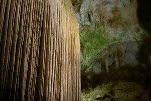 il grotta è carsico, sorprendente Visualizza di stalattiti e stalagmiti illuminato di luminosa luce, un' bellissimo naturale attrazione nel un' turista posto. foto