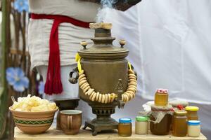 un vecchio russo samovar con bagel e miele prodotti su il tavolo. foto