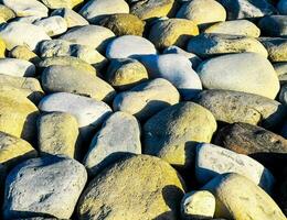 un' grande mucchio di rocce su il spiaggia foto