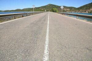 un' lungo vuoto strada con un' cartello su esso foto