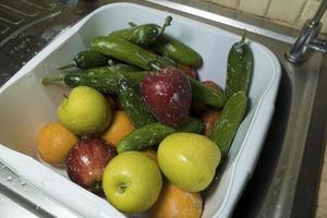 mele fresche saponose cetrioli e arance in cucina foto