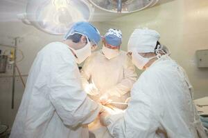 chirurgico Dipartimento di il Ospedale. medici eseguire chirurgia su un' paziente sotto lampade. foto