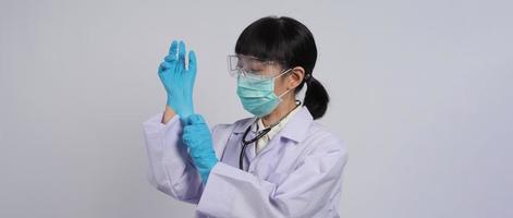 indossare i guanti. il medico asiatico indossa un guanto per le mani in nitrile di gomma blu.