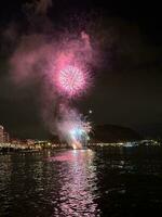 colorato fuochi d'artificio nel il notte cielo su il lungomare di alicante Spagna foto