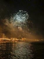 colorato fuochi d'artificio nel il notte cielo su il lungomare di alicante Spagna foto