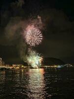 colorato fuochi d'artificio nel il notte cielo su il lungomare di alicante Spagna foto