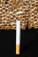 un' sigaretta è mostrato nel davanti di un' mucchio di sigarette foto