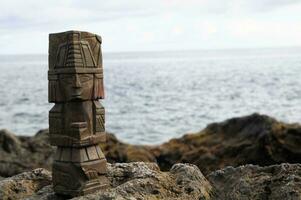 un' di legno totem su il rocce di il oceano foto