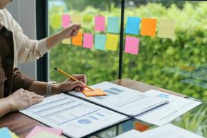 attività commerciale persone Lavorando su appiccicoso Appunti creativo scrittura giù idee su inviare esso Appunti professionale investitore inizio su progetto attività commerciale. foto