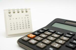 calcolatrice e calendario su bianca sfondo per i soldi e debito gestione concetto. economico calcolo prima 2024. foto
