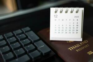 semplice scrivania calendario per dicembre 2023 e passaporto. calendario e vacanza concetto con passaporto su il scrivania. copia spazio. foto