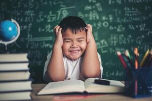 ragazzo preoccupato in classe con le mani sulla testa foto