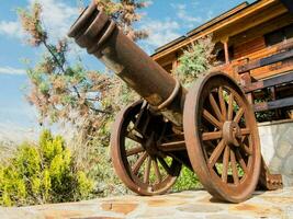 un vecchio cannone su il pietra parete nel davanti di un' Casa foto