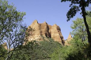 vista dal basso di una montagna rossa, antica miniera d'oro foto