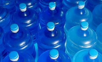 superiore Visualizza di foderato su plastica grande bottiglie blu galloni di purificato potabile acqua dentro il produzione linea. acqua bevanda fabbrica foto