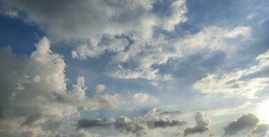 un' blu cielo con nuvole e un' pochi nuvole, blu cielo, bianca nube tempo periodo di nuvole nel il cielo, il sole brilla attraverso il nuvole nel Questo foto, drammatico cielo nuvole foto