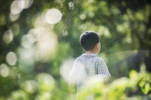 vicino posteriore del ragazzino che cammina nel parco. foto