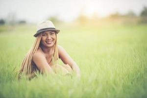 giovane donna seduta sentirsi bene nel campo in erba.