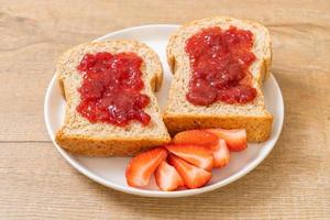 pane integrale con marmellata di fragole e fragole fresche foto