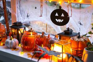 festivo arredamento di il Casa su il davanzale per Halloween - zucche, Jack o lanterne, teschi, ragnatele, ragni, scheletri, candele e un' ghirlanda - un' accogliente e terribile umore foto