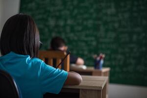 ragazzo scrivere un libro in classe. foto