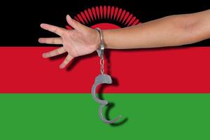 manette con la mano sulla bandiera del malawi foto