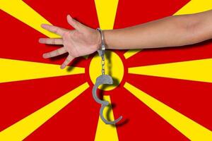 manette con la mano sulla bandiera della Macedonia foto
