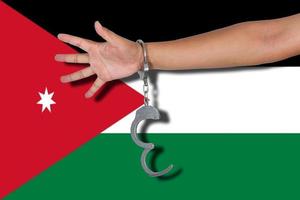 manette con la mano sulla bandiera della giordania