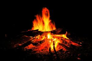 fuoco di bivacco a notte con fiammeggiante legna ardente foto