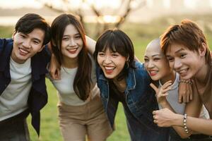 Immagine di un' gruppo di giovane asiatico persone ridendo felicemente insieme foto