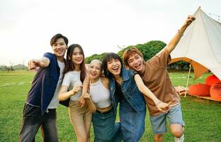 Immagine di un' gruppo di giovane asiatico persone ridendo felicemente insieme foto