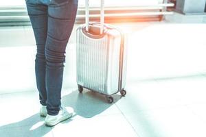 primo piano donna e valigia trolley bagagli in aeroporto foto