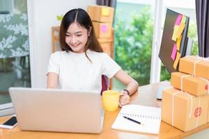 la donna asiatica si diverte mentre usa internet su laptop e telefono