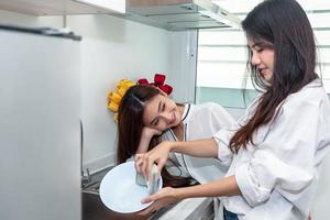 due donne asiatiche che lavano i piatti insieme in cucina
