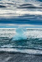 diamante spiaggia con iceberg fusione su nero sabbia spiaggia nel estate a Islanda foto