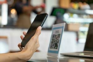 donna uso smartphone per scansione qr codice per pagare nel bar ristorante con un' digitale pagamento senza Contanti. scegliere menù e ordine accumulare sconto. e portafoglio, tecnologia, pagare in linea, credito carta, banca app. foto