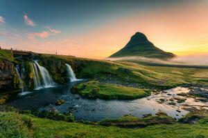 Alba al di sopra di vulcanico Kirkjufell montagna con cascata fluente e nebbioso nel estate a Islanda foto