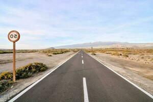 un vuoto strada nel il mezzo di un' deserto foto