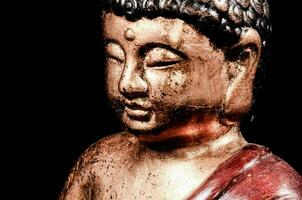 un' statua di un' Budda con un' rosso stoffa foto