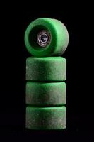 un' pila di verde skateboard ruote su un' nero sfondo foto