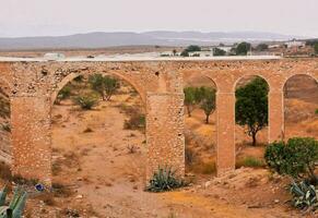 il rovine di un vecchio acquedotto nel il deserto foto