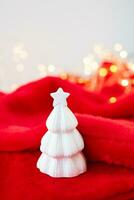 Natale casa interno con un' bianca ceramica Natale albero su un' rosso lenzuolo. Natale e nuovo anno concetto. verticale foto. foto