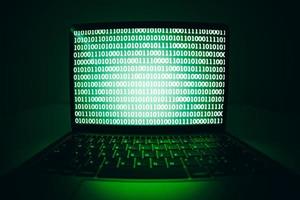 schermo del codice binario del laptop, virus o malware per hackerare il server Internet foto