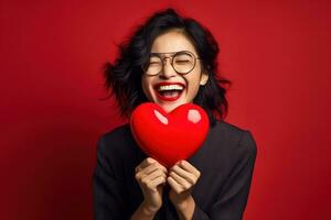 ritratto di un' contento donna con rosso cuore su un' rosso background.valentine's giorno concetto ai generato foto