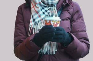 un irriconoscibile ragazza, un' donna con un' bicchiere di caffè nel polli, vestito nel un' Borgogna giacca, un' scacchi sciarpa e nero guanti. stile di vita foto. foto